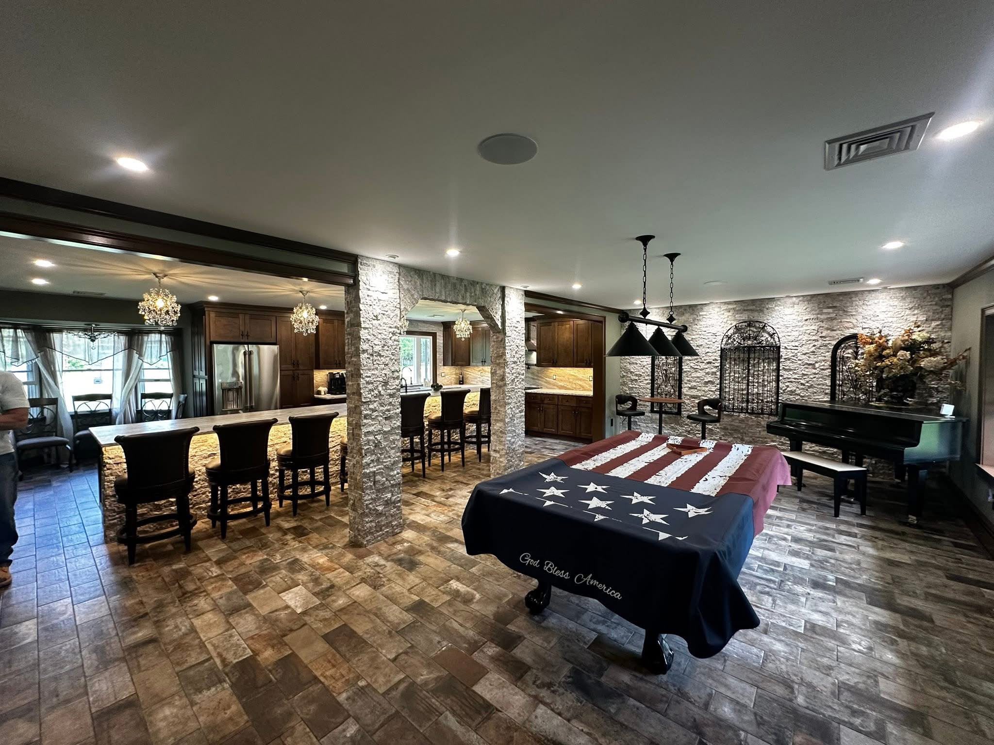 Large finished basement with stone columns and bar