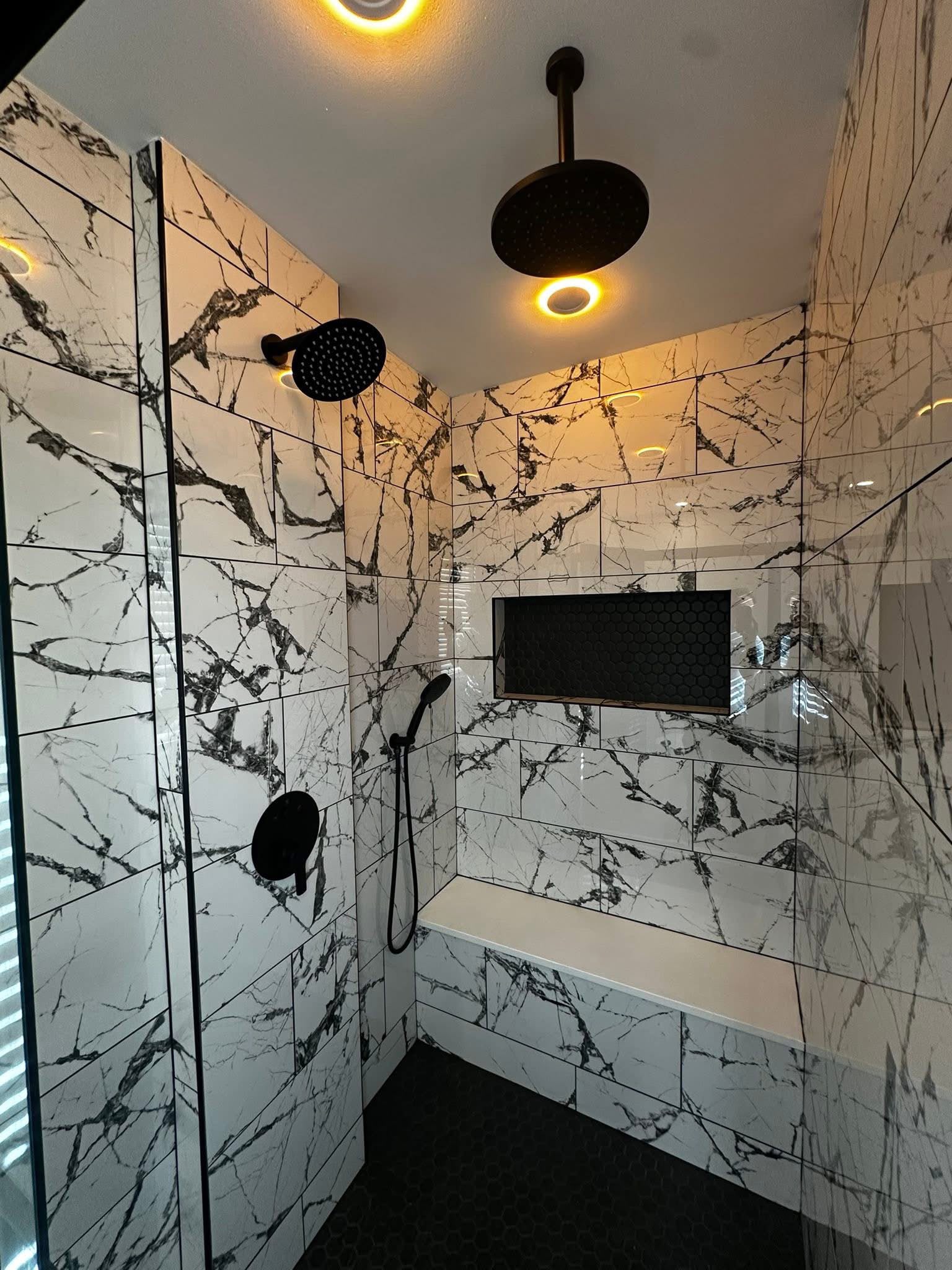 Marble-look tile walk-in shower with black fixtures