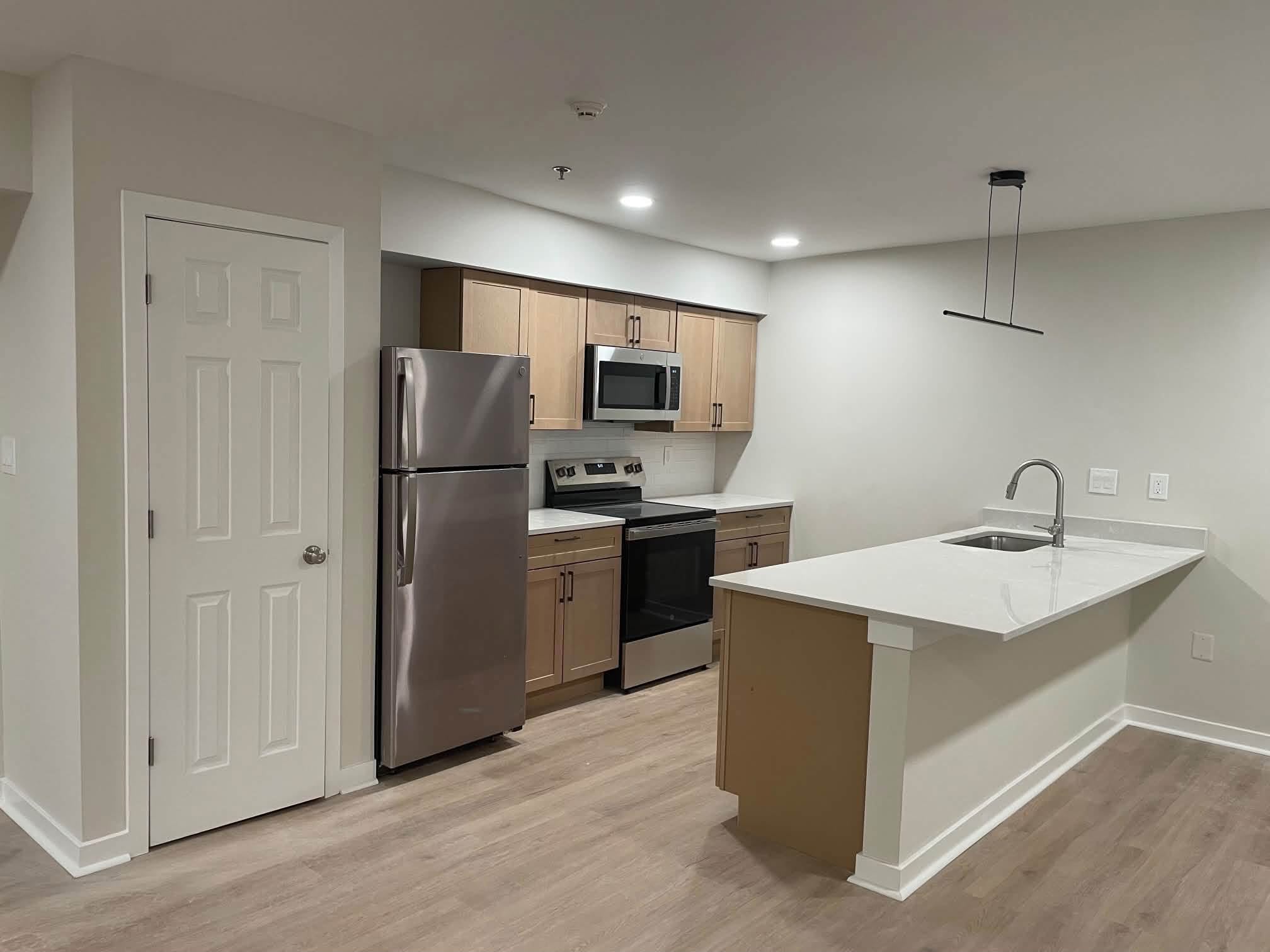 Maple kitchen cabinets with white quartz island