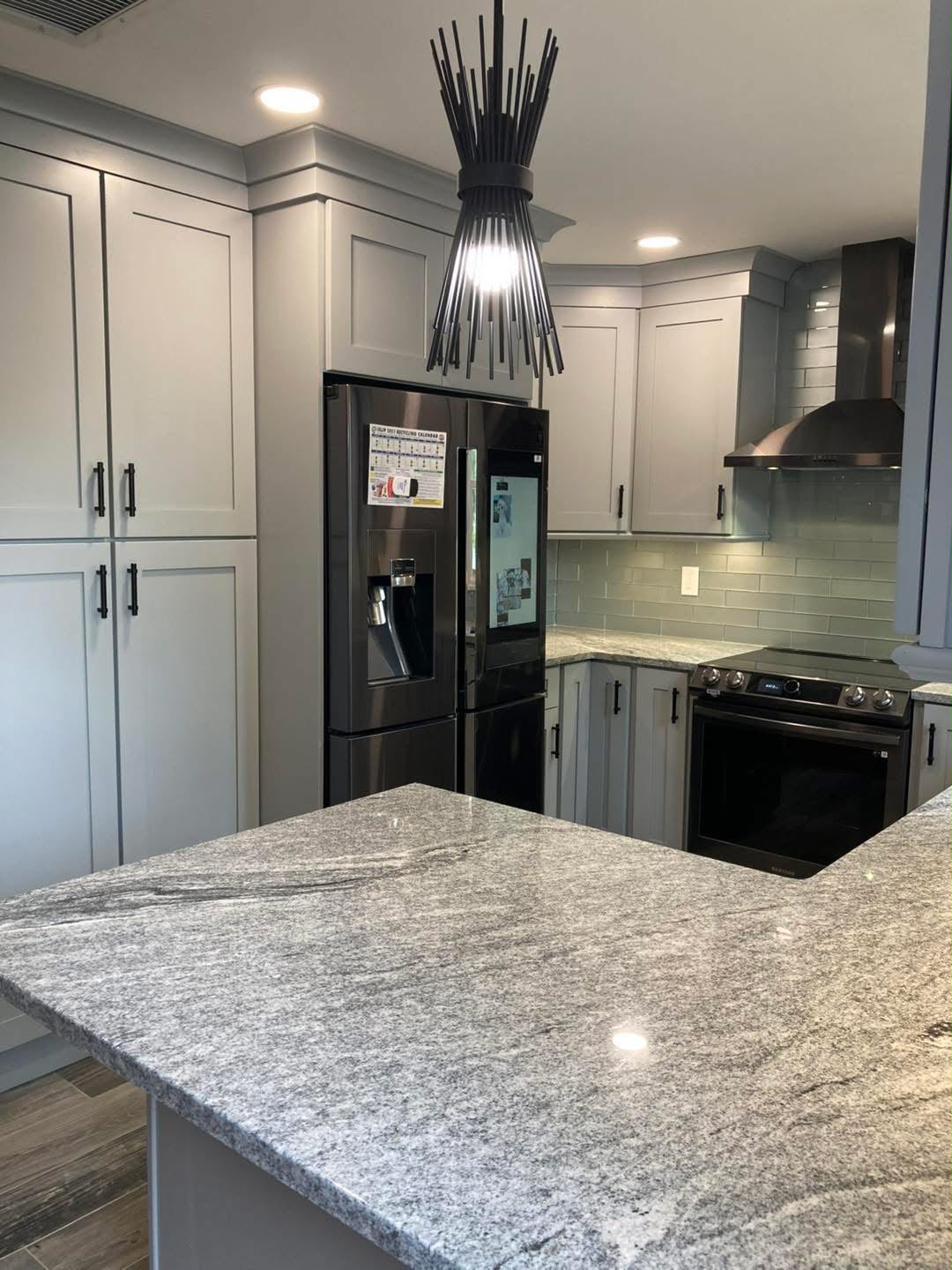 Gray kitchen with granite island and pendant light